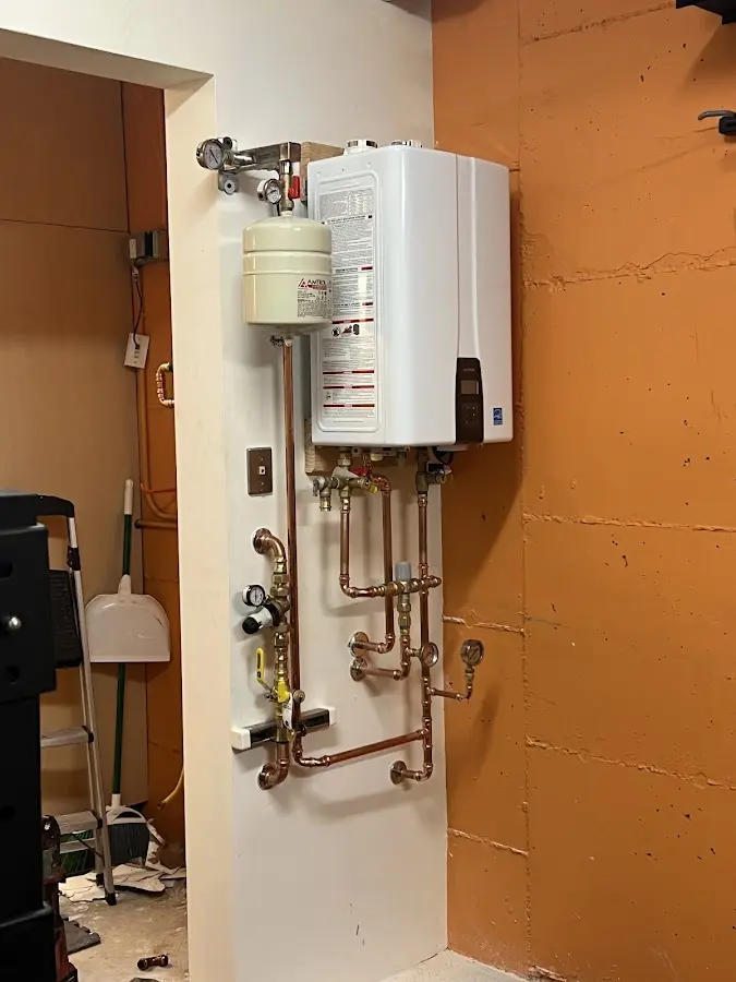 Plumbing technician inspecting water heater connections in Tyrone